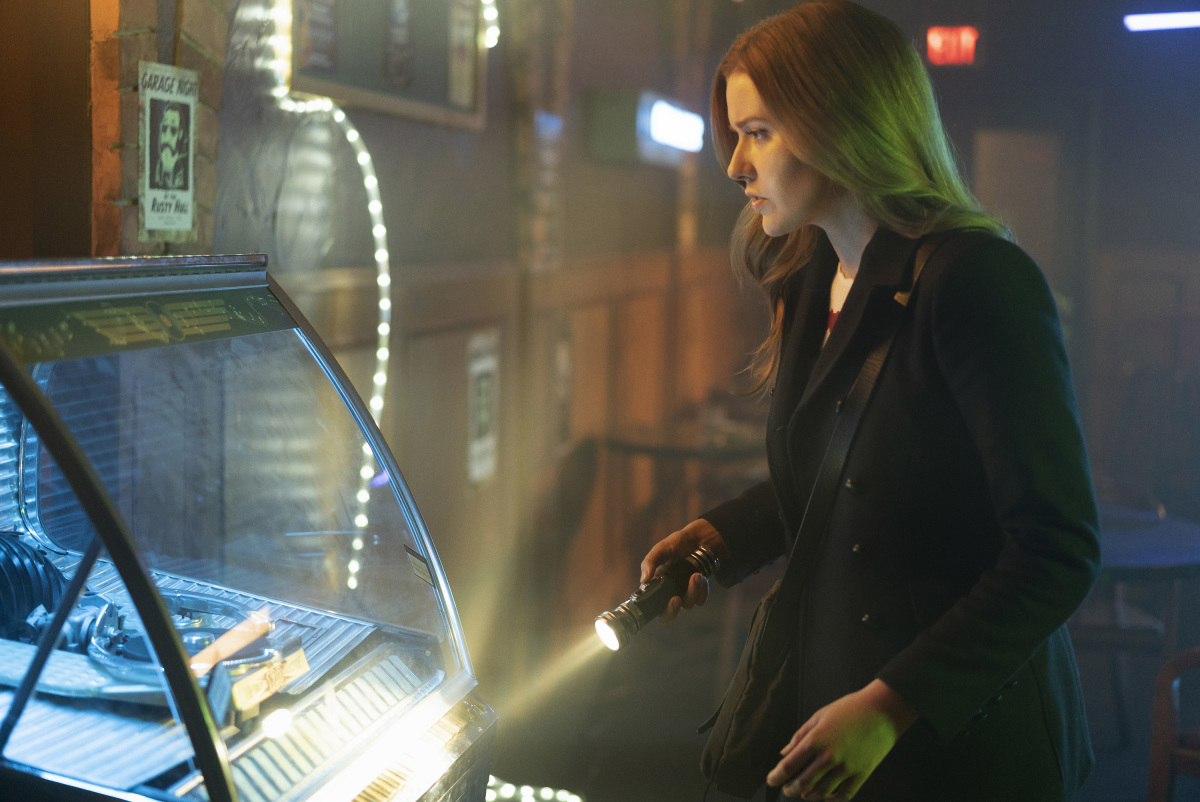 Nancy Drew with her flashlight investigating a jukebox